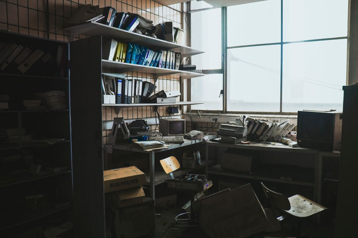 Dusty, chaotic office storage room with scattered files before cleaning